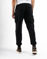 Pantalón tipo cargo de felpa color negro, con cintura elástica ajustable mediante cordón, bolsillos laterales tipo cargo y puños elásticos en los tobillos.