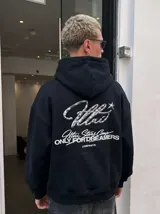 Hoodie negro con capucha, de corte oversize y confección en felpa, con estampa metalizada y gráfica en la espalda.