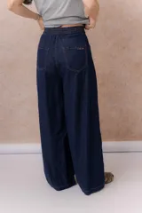 Jean de calce amplio y relajado, color azul, con pierna extra ancha y caída fluida. Diseño de tiro alto con pinzas delanteras y lazo regulable en la cintura. Cuenta con bolsillos laterales y traseros.