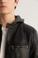 Campera de cuero sintético negra con capucha de algodón gris, cierre frontal con cremallera, bolsillos laterales con cremallera y detalles acolchados en hombros y mangas.