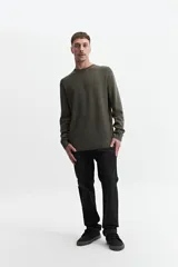 Buzo tejido de punto color verde militar, con escote redondo y puños. Corte regular. Confeccionado en 100% algodón.
