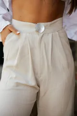 Pantalón de corte amplio y relajado, confeccionado en una mezcla de lino y algodón. Presenta una caída fluida, cintura alta y bolsillos laterales.