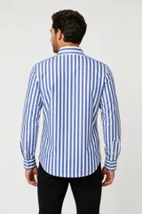 Camisa de algodón a rayas verticales azules y blancas, de manga larga, con cuello camisero y cierre frontal con botones.