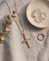 Collar de bronce con baño de oro y dije de cruz decorado con piedras naturales rosadas y circonias.