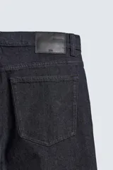 Jeans de corte slim fit en color azul oscuro, con diseño de cinco bolsillos, cierre frontal con cremallera y botón, y tejido ligeramente elástico.