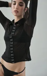 Camisa negra de microtul elastizado, con cuello clásico, mangas largas y cierre frontal con hilera de ganchos metálicos.
