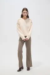 Sweater de algodón color natural, de corte holgado y cuello redondo. Presenta detalles de costuras decorativas con bordado en los hombros y puños acanalados.