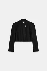 Blazer corto de lino en color negro, con cuello redondo y cierre frontal cruzado con un botón.