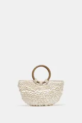 Bolso de mano tipo media luna con apliques nacarados, doble asa circular de madera y asa bandolera de cadena extraíble. Incluye forro y bolsillo interior.