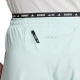 Short de running Adidas Own The Run color celeste con cintura elástica negra con la inscripción "Running" en blanco. Presenta las tres tiras características de la marca en color blanco en los laterales y el logo en la parte inferior.