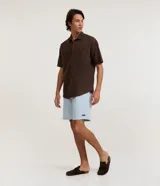 Bermuda masculina de sarga confeccionada en mezcla de algodón y poliéster, con diseño de estampa rayada. Posee cintura elástica con cordón de ajuste y bolsillos laterales.