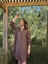 Vestido camisero color beige claro, de lino 100% natural, con botones de nácar, bolsillo delantero y mangas 3/4 con botón para recogerlas. Diseño asimétrico, más largo en la parte trasera.