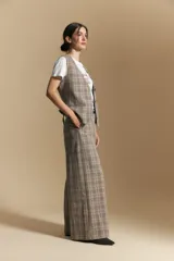 Pantalón de tiro alto con diseño a cuadros, corte wide leg y silueta amplia de caída fluida.