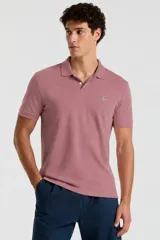 Chomba de manga corta de color rosado con cuello camisero, tapeta con botones y logo bordado del pingüino en el pecho izquierdo.