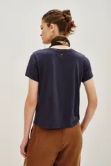 Remera de cuello redondo y manga corta en color azul oscuro, con un sutil estampado lineal de un felino en el centro del pecho.