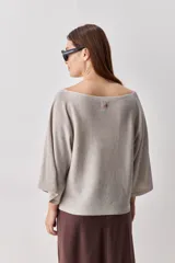 Sweater de punto liviano negro, con escote bote y mangas amplias de largo tres cuartos que aportan una silueta relajada y fluida.