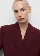 Americana de corte recto y diseño estructurado en color bordó. Presenta cuello con solapas de muesca, cierre frontal con botón, bolsillos laterales con solapa y un bolsillo de ribete en el pecho. Incluye forro interior completo y mangas largas.