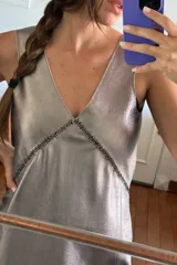 Minivestido plateado con escote en V, bordado al frente y espalda descubierta.