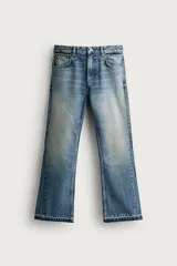 Jeans flare fit de denim de algodón en color celeste con lavado efecto desgastado. Presentan diseño de cinco bolsillos, tiro medio, cierre frontal con cremallera y botón, y bajo con acabado irregular.