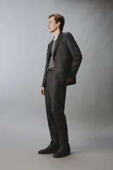 Blazer de corte regular confeccionada en lana de origen italiano, con diseño a cuadros sutiles. Presenta cuello con solapas de pico, cierre frontal de botones, bolsillos de solapa en la cadera y bolsillo de vivo en el pecho.