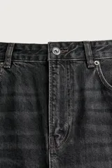 Jeans flare fit de denim negro, tiro medio, ajustados arriba y con botamanga acampanada. Cuentan con cinco bolsillos, lavado efecto gastado y bajo con acabado irregular. Cierre frontal con cremallera y botón.