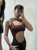 Body negro con cuello halter, abertura en el abdomen y espalda descubierta.