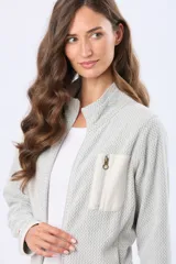 Campera de micropolar con textura en relieve, cierre frontal completo y cuello alto. Presenta un bolsillo vertical con cierre en el pecho y detalles de terminación en color contrastante.