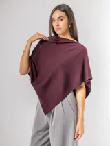 Poncho de corte holgado y diseño minimalista, confeccionado en tejido liviano de color beige, con cuello redondo y caída fluida.
