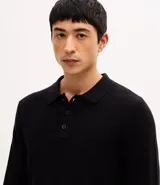 Suéter masculino de punto texturizado en color beige, con cuello polo, cierre frontal de tres botones, manga larga y terminaciones acanaladas en puños y ruedo.