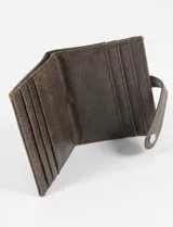 Tarjetero de cuero vegano con acabado brillante, cierre con solapa y broche a presión. Cuenta con ranuras para tarjetas y detalle de logo metálico en la parte frontal.