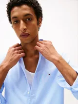Camisa celeste de popelina de algodón con Flex Technology, corte regular, cuello abotonado, puños redondeados con dos botones, microestampado integral y logo de Tommy Hilfiger bordado en el pecho.