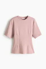 Remera de punto interlock pesado en color rosado, con cuello redondo y mangas cortas. Presenta cintura entallada con pinzas moldeadoras en la parte delantera que generan un sutil efecto peplum.