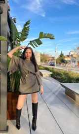 Blusa verde con mangas anchas, corte holgado y cinturón dorado con hebilla cuadrada.