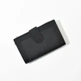 Billetera negra de cuero sintético con cierre de broche.