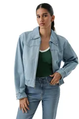 Campera de jean de corte corto con cierre frontal, cuello clásico y cintura elástica. Presenta mangas largas con puños abotonados y costuras tipo western en el pecho.