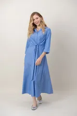 Vestido midi cruzado de seda con estampado de rayas celestes y blancas, escote en V con solapa, mangas tres cuartos y detalle de nudo drapeado en la cintura.