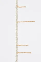 Pulsera dorada con perlas de resina y finas cadenas colgantes, con cierre de mosquetón ajustable y dije de corazón esmaltado.