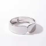 Brazalete rígido plateado con cierre de resorte.