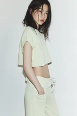 Camiseta cropped color verde menta, con cuello redondo y mangas cortas amplias con dobladillo.