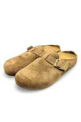Zuecos de gamuza color amarillo, diseño cerrado en la parte delantera y destalonado, con una tira superior ajustable mediante hebilla metálica.