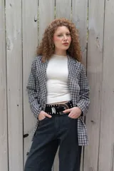 Blazer de paño con estampa a cuadros en tonos marrones y beige, de corte recto y mangas largas.