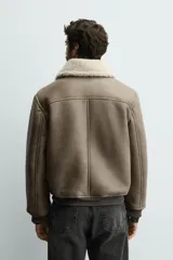 Cazadora de corte regular fit confeccionada en tejido efecto piel color marrón, con interior de borreguillo a contraste. Presenta cuello solapa con trabilla, cierre frontal de cremallera, bolsillos de vivo en la cadera y puños y bajo acabados en rib.