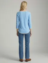 Remera de modal color blanco, con cuello redondo y mangas 3/4. Presenta un aplique bordado en color tostado en el cuello, los puños y el ruedo.