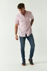 Camisa de manga corta confeccionada en una mezcla de lino y algodón, con cuello camisero, cierre frontal de botones y bolsillo en el pecho con logo bordado.