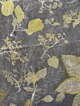 Mantel rectangular de algodón color gris con estampado de hojas y flores en tonos amarillos y marrones.