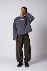 Buzo oversize de corte boxy, confeccionado en algodón rústico de alto gramaje en color beige. Presenta cuello redondo con borde crudo, mangas largas y una estampa frontal con el texto VCP delimitado por líneas horizontales blancas.