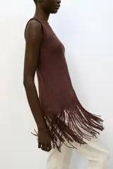 Top de cuello redondo y manga sisa, color marrón, con bajo asimétrico de flecos combinados a tono.