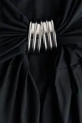 Top halter extralargo de punto elástico, color negro, con maxiescote drapeado, tiras finas para anudar al cuello y diseño asimétrico con fruncidos en los laterales.