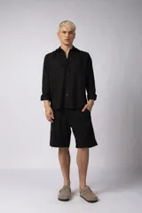 Camisa de manga larga con cuello clásico y cierre frontal de botones. Presenta un calce relajado y una textura liviana.