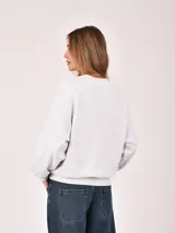Buzo de cuello redondo en color gris melange, con diseño de corte holgado y mangas largas con puños elásticos.